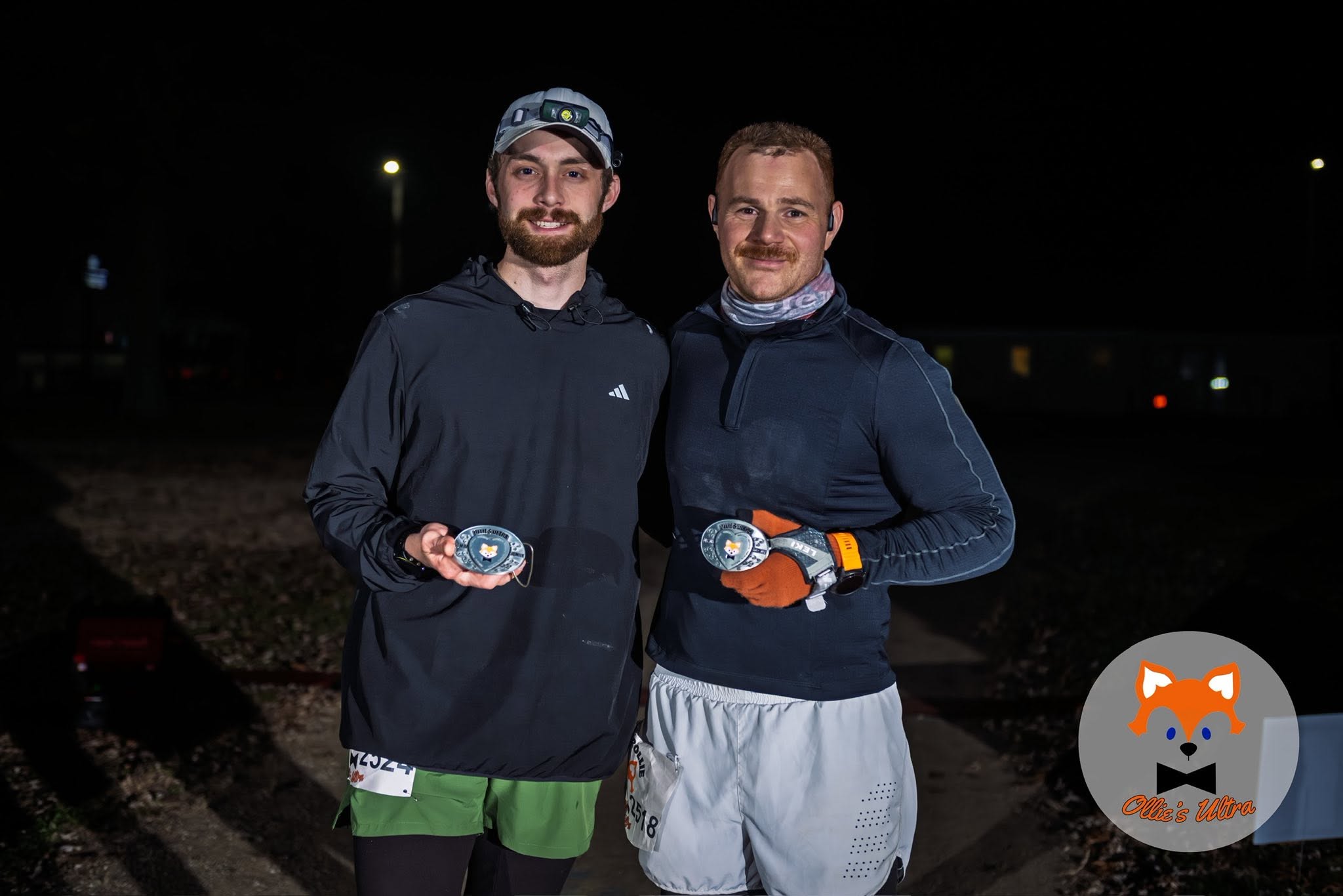 Aryeh Goldman holding a finisher medal after a night ultramarathon.